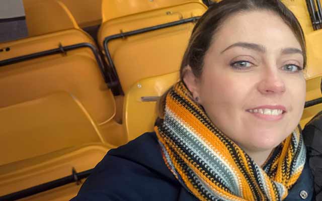 Samantha Baker wearing a scarf in a football stadium