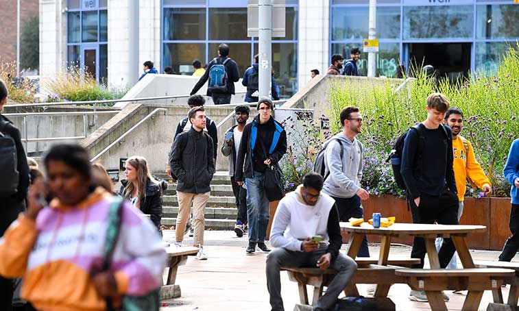 Students walking outside of the the on a clear day