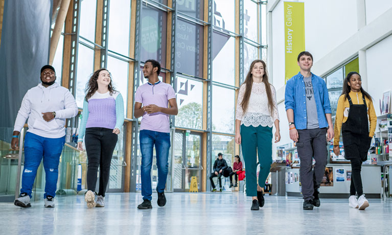 A diverse group of students walking through the open and light Herbert Art Gallery and Museum in Coventry.