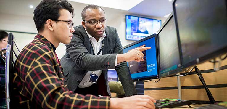 Student in front of monitors in Trading Floor