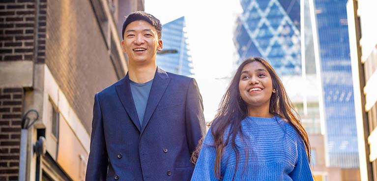 Male and female student walking outside on London street