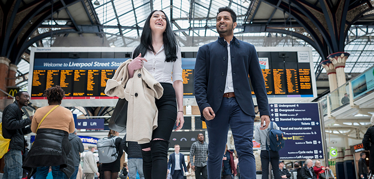 Man and woman walking together in a train station