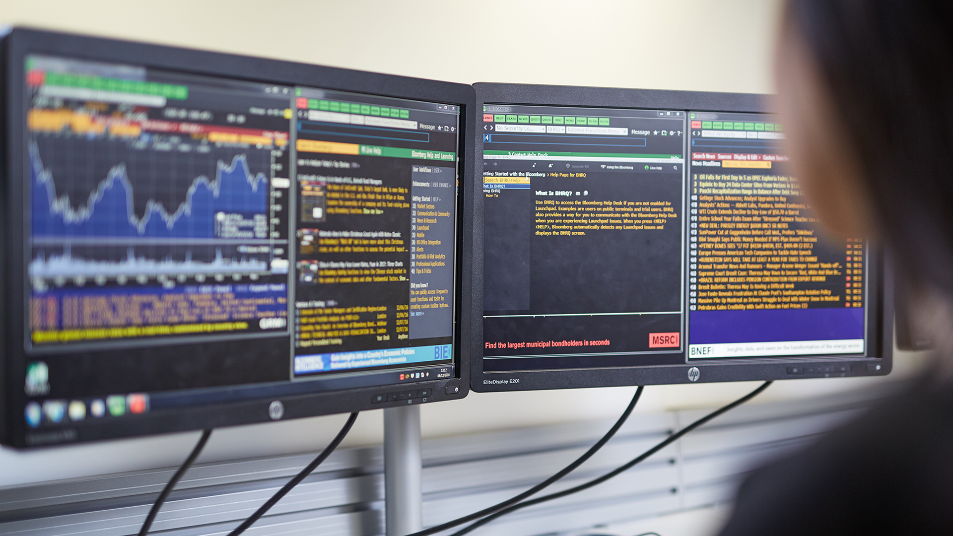 Two computer screens showing data graphs and coding