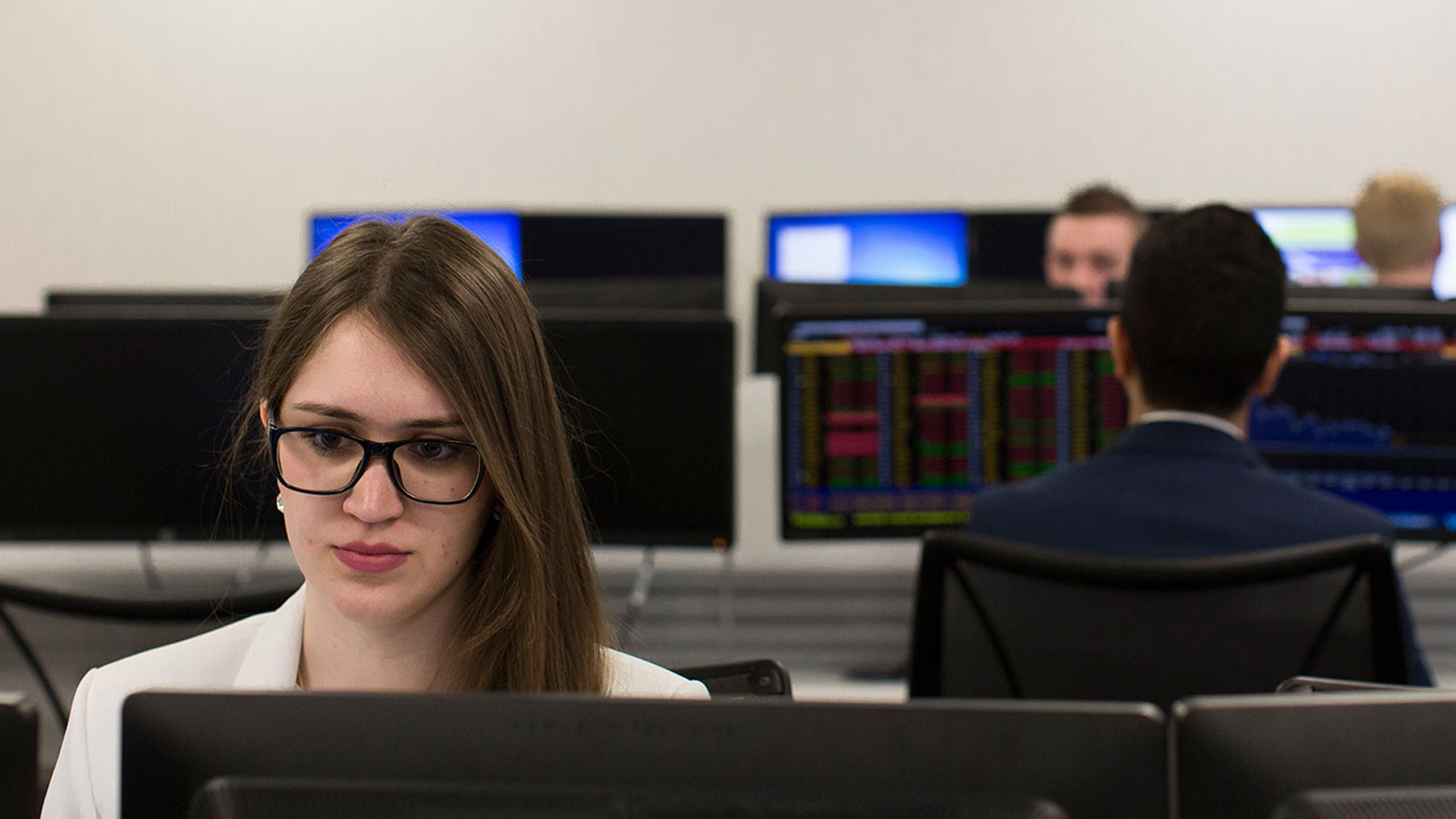 Female sitting in a classroom looking at a screen