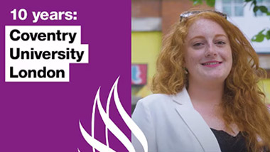 woman smiling for a photo outside a university building