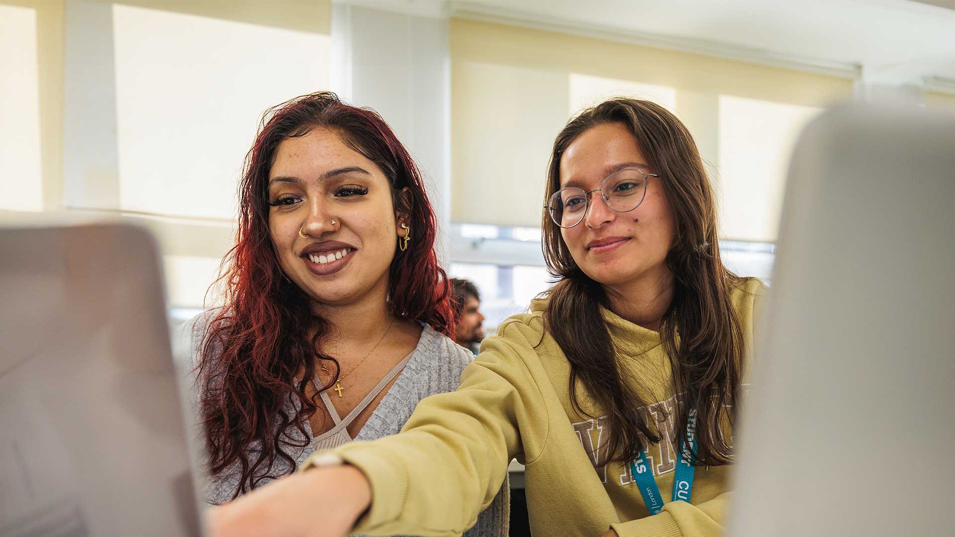 Two female students working on their laptops 