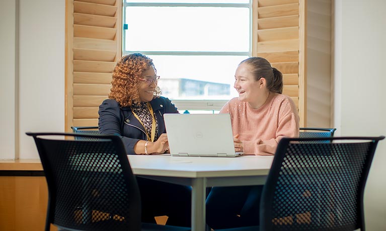 Two students sat next to each other talking