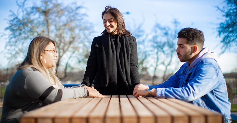 Three students outside talking