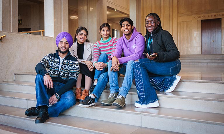 Group of students sat on some steps