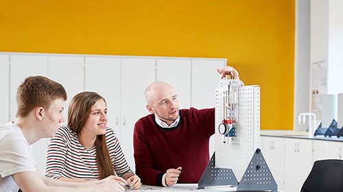 Three Electro-Mechanical Engineering students using equipment.