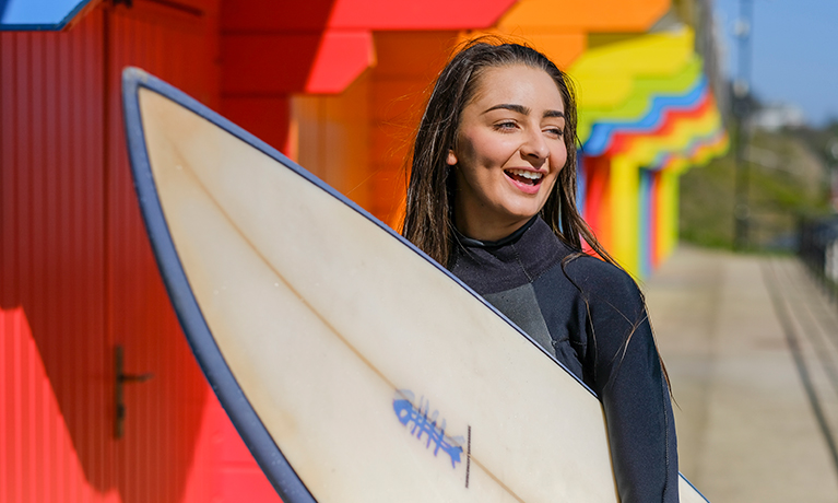 girl walking with a surfboard