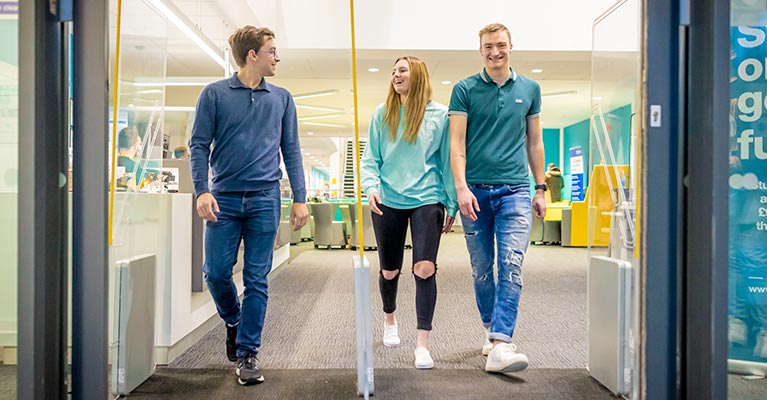 Three students walking towards the exit