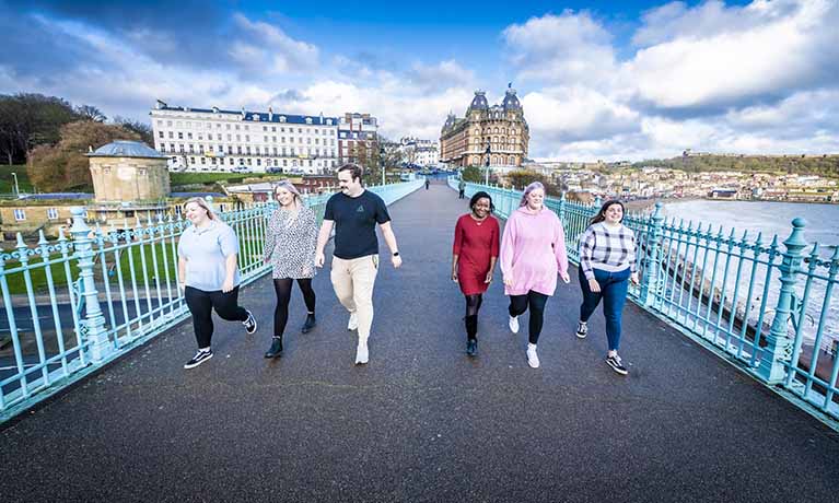 Group of students walking past the Scarborough sea front