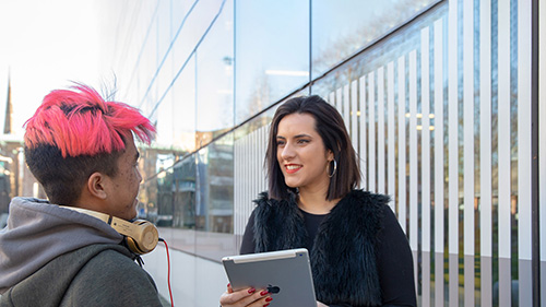 Two students outside the Hub on campus