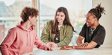 Three students sat together socialising 