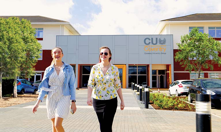 Two students walking outside the Mile Lane campus entrance