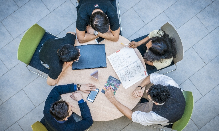 Group of people sitting around a table talking