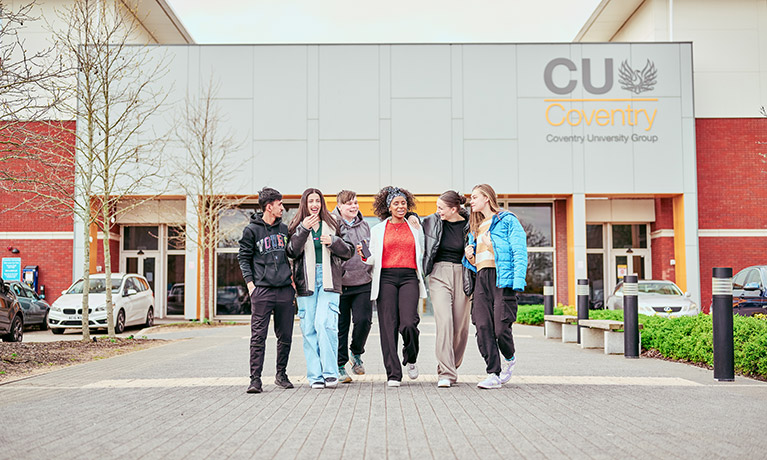 Group of students talking whilst walking away from CU Coventry