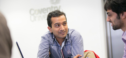 Lecturer talking to students in front of a whute board