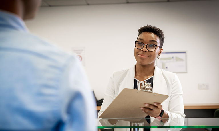 Woman holding a clipboard writing notes