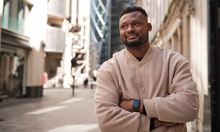 Male student standing in finance district of London