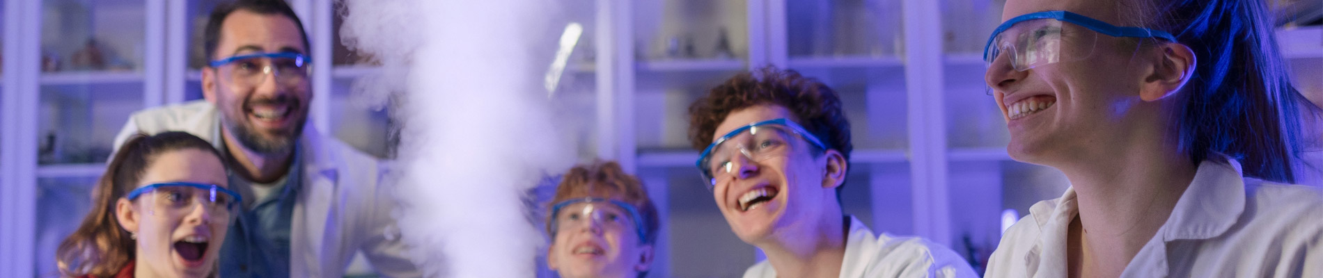 Two teachers doing a science experiment with a class, with steam rising up into the air.