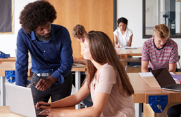 A teacher helping an older student in class.