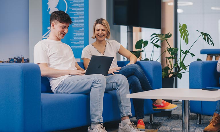 Two students sat working on their laptops