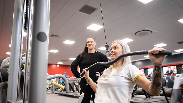 Female student and her Personal trainer at the gym